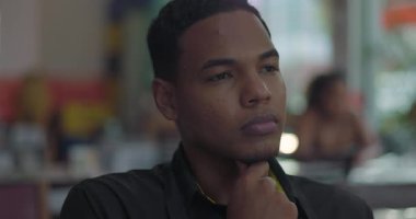 Genç restoran çalışanlarının renkli yakın plan resimleri. Düşünceli bir tavırla çenelerini dinlendiriyorlar. Sessiz yemek odasının penceresinde oturuyorlar.