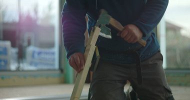 İnşaat işçisi yerde odun testeresi, el testeresi ile yakın plan, kapalı alanda ahşap kesme, ayrıntılı işçilik.