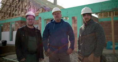 İnşaat alanında çalışan bir grup inşaat işçisi, birlik içinde duruyorlar, inşaat alanında işbirliği yapan inşaat profesyonelleri, takım çalışması ve koordinasyon