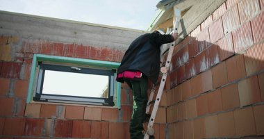 İnşaat alanına inen işçi merdiveni, takım çalışması ve güvenlik odağı, konut inşaatı ve açık hava inşaat projesi çalışmalarının tamamlanması