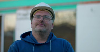 İnşaat işçisi, kasketli, içerik ifadeli, inşaat projesinde, açık havada, açık havada.