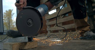 Açı öğütücüye yakın çekim, metal bloğu kesme, inşaat sahasında uçuşan kıvılcımlar, hassasiyet ve el yapımı endüstriyel görev süper yavaş çekimde 800 fp