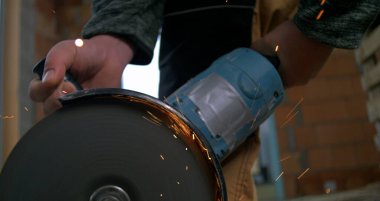 Metal kesim sırasında dönen bıçağı ve kıvılcımları olan güçlü bir açı öğütücü. Endüstriyel yapı çok yavaş çekimde.