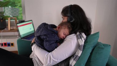 Anne kucağında uyuyan bir bebeği tutarken kulaklıkla birden fazla iş yapıyor. Ev ortamında dizüstü bilgisayarla çalışıyor. Anneliği ve mesleki sorumlulukları birbirine karıştırıyor.