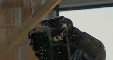Tahtayı yavaş çekimde 800 fps hızla kesen elektrikli testere, yakın çekimde bıçak kesme, tahta enkazı ve kıymıklar uçuşuyor, elektrikli testere hareketinin detaylı görüntüsü