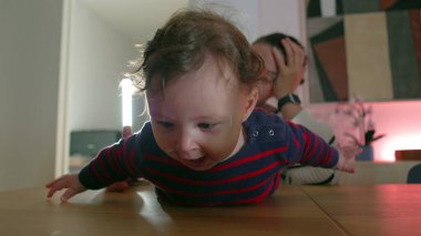 Bebek masada yatarken gülümsüyor, kollarını oynak bir şekilde uzatıyordu, mutlu bebek anın tadını çıkarıyordu, enerjik ve heyecanlı, kapalı bir aile sahnesi.