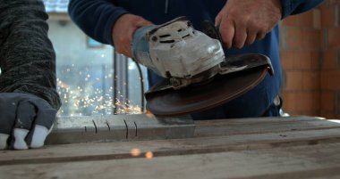 Metal üzerinde açı öğütücü kullanan işçilere yakın çekim, aydınlatıcı eller, inşaat ortamında hassasiyet ve takım çalışmasına odaklanma, 800 fp yavaş çekim.