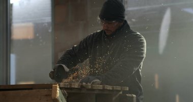 800 fps 'te yavaş çekimde kıvılcımlar saçan bir işçi, metal kesimine yoğun odaklanma, koruyucu giysi giyme, kapalı alanlarda endüstriyel ayarlar