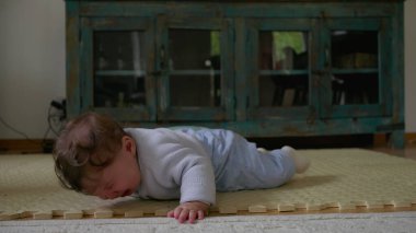 Bebek yüzüstü yere yatar, dokunsal nesneleri keşfettikten sonra hayal kırıklığını ifade eder, hareket becerilerini geliştirirken bağımsız bir oyun oynar, çocukluk duygularını geliştirir.