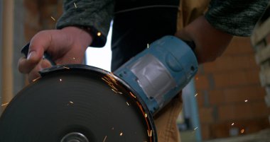 Metal kesim sırasında dönen bıçağı ve kıvılcımları olan güçlü bir açı öğütücü. Endüstriyel yapı çok yavaş çekimde.