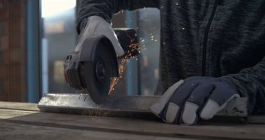 Açı öğütücüyle metal atölyesinde çalışmak, eldivenli ustalıkla uçan kıvılcımlar metali maharetle keser, hassasiyete yoğunlaşır, 800 fp yavaş çekim