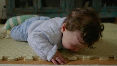 Bebek mindere uzanıyor, oyun zamanı dokulara ve dokunsal hislere odaklanıyor, motor becerilerini geliştiriyor ve duyusal keşiflere katılıyor.