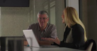 İş arkadaşları gülümser ve ofis toplantısında dostça destek anlarında el ele tutuşur, takım çalışmasını kutlar ve başarıyı paylaşırlar.