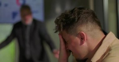 Stresli ekip üyeleri konferans masasının etrafında kaygı ve utançla tepki verirken kızgın yönetici, çalışanlarla hararetli ofis toplantısında yüzleşiyor