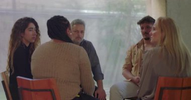 Terapi grubu destek çemberine oturdu, grup terapisi sırasında duygusal ifadeleri dikkatle dinleyen bireyler