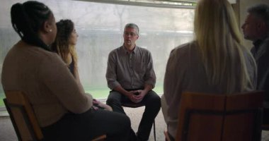 Orta yaşlı bir adam yoğun terapi seansı sırasında ham duygusal ifadeyle açılır. Destek grubu, güvenli uzayda derin kişisel acılarını açığa çıkarırken sessizce dinler.