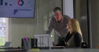 İş arkadaşları ofis masasında verileri incelerken gülümseyen ve tezahürat yapan olumlu sonuçları kutladılar