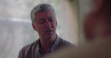 İnsan terapi seansı sırasında kasvetli ve düşünceli görünür. Duyguları sindirirken ve başkalarını dinlerken destekleyici bir ortamda sessizce oturur.