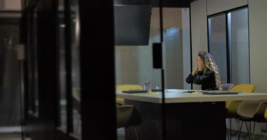 Genç bir kadın cam duvarlı ofiste tek başına oturuyor. Yüzü ellere gömülü. Yüksek basınçlı iş gününün ardından bitkin ve duygusal olarak tükenmiş.