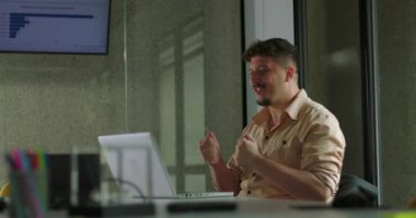 Mutlu genç adam, solo ofis çalışması sırasında laptopta tek başına başarıyı kutluyor.