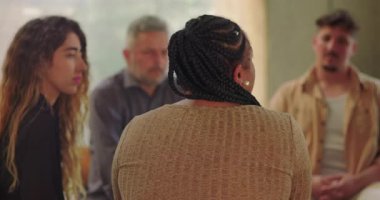 Destek grubu, duygusal terapi sırasında iyileşme çemberinde oturan kadının hikayesini dikkatle dinliyor.