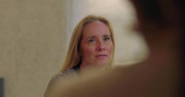 Grup terapi seansında yürekten bir hikâyeyi paylaşan kadın, akranlarıyla iletişim ve yansıma anında üzüntü ve hassasiyetin duygusal ifadesi.