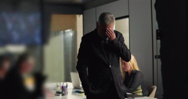 İş adamı, şirket krizi sırasında arka planda çalışan kadın meslektaşı olarak toplantı odasında el üstünde tutarak son derece stresli bir şekilde duruyor.