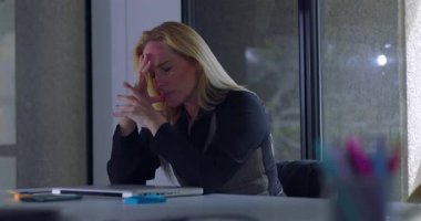 İş kadını, sakin modern ofiste, yoğun stres anlarında iş baskısı ve yorgunlukla boğuşuyor.