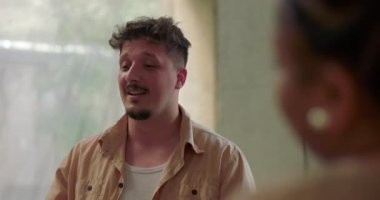 Grup terapisi sırasında bir adam kendini kaybediyor. Duygusal olarak başı öne eğik bir şekilde grup üyelerinden biri omuz omuza, güven verici bir şekilde sessiz destek veriyor.