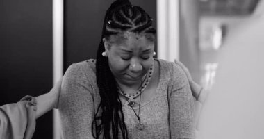 Duygusal terapi sırasında teselli bulan ağlak kadın, grup üyeleri güçlü bir paylaşımlı hassasiyet anında, siyah ve beyaz