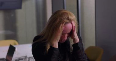 İş yerindeki stresin kırılma noktasına ulaştığında, ofis toplantısı sırasında dişlerini sıkan sarışın iş kadını, bunalmış ve gergin.