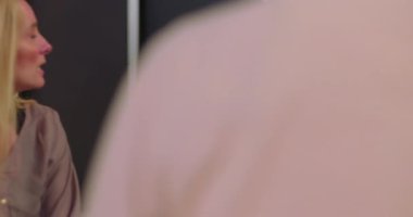 Terapi seansında düşüncelerini paylaşan bir kadın savunmasızlığını dile getirirken grup güvenli bir ortamda şifa ve bağlantı için dinliyor.