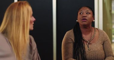 Terapi seansı sırasında konuşan kadın, destek grubu ortamında duygusal hikaye aktaran anlamlı el hareketleri.