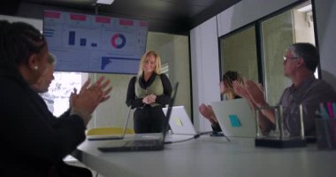 İş kadını modern kurumsal ofis konferans odasında sunumu tamamladıktan sonra ekipten alkış aldı