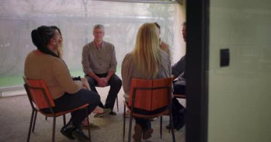 Terapi seansı sırasında çemberde oturan destek grubu katılımcıları, çeşitli bireyler kapalı alan ortamında duygusal tartışmalara girdiler.