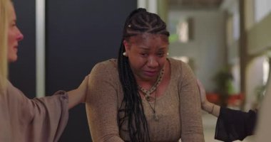 Destek grubu üyeleri ağlayan kadını teselli etmeye çalışıyor. Duygusal çöküntü, empati ve iyileşme camiası ortamında teşvik ile karşılandı.