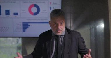 Ekip büyük ekranda veri analizini dinlerken, yönetim kurulu başkanının heyet odasında tutkulu bir sunumu var.