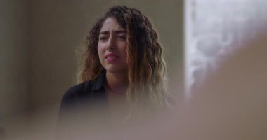 Grup terapisinde konuşurken duygulanan genç kadın, destekleyici ve önyargısız ortamda zor bir deneyim yaşarken gözleri kapalı