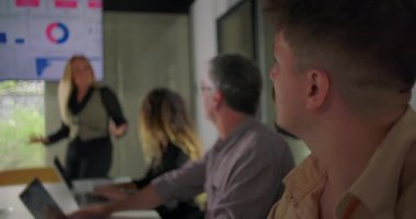 İş kadını, sunum sırasında sunum sırasında, kurumsal konferans odasında veri paneli eşliğinde takım izlemesi yaparken el kol hareketi yapıyor