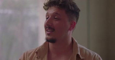 Grup terapisi sırasında kişisel hikâyesini ifade eden bir adam, empati ve destek çemberi içinde dinlerken duygu ve açıklıkla konuşur.