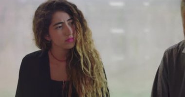 Orta yaşlı bir adam terapi sırasında duygularını paylaşıyor. Samimi bir şekilde grup üyelerinin yanında oturuyor. Sakin, kapalı bir ortamda.