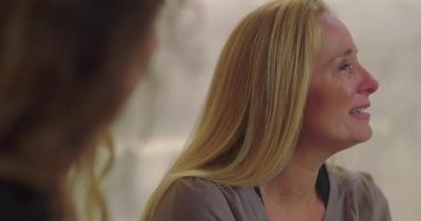 Grup terapisi sırasında duygu yüklü ağlayan kadın empati, iyileşme ve destek alanlarında acı ve hassasiyetini ifade ediyor.