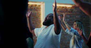 Cemaat birbirine tapıyor, insan duygusal ifadeyle el kaldırıyor, çeşitli grup duaları, neşeli kutlamalar, kilisede Hıristiyan ruhaniliği.