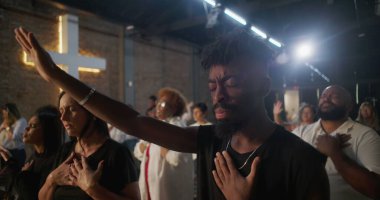 Afrika kökenli Amerikalı bir adam, el kaldırılmış ve kalpten bağlanmış, arka planda parlayan, derin ruhsal bağlantı, inanç ve kutsal kilise hizmetinde birlik.