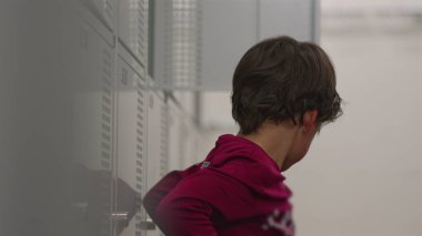 İlk hokey tecrübesinden sonra soyunma odasında oturan genç bir çocuk, maçı, maç sonrası düşünme ve spor ortamında öğrenme anını yansıtıyor.