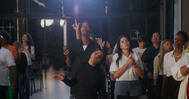 Kilise ortamında grup ibadeti, dua eden, el kaldıran, ruhani bağlantı ve inanç, içeride sadakat ve birliği ifade eden çeşitli gruplar.