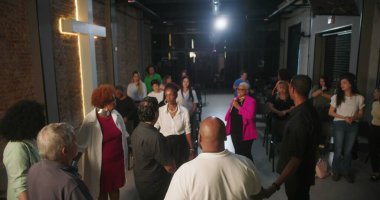 Dua ve ibadete katılan cemaat, ruhani bağlantılara odaklanmış, modern evanjelik kilise ortamında lider rehberlik hizmeti