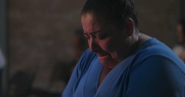 Başı sessizce dua eden, mavi giyen, ruhani yansımaya dalmış ve ibadet sırasında inançla barışçıl bir bağ kuran bir kadın.