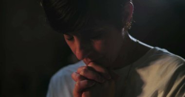 Dua eden kadın, elleri sessiz ruhani yansımayla birbirine kenetlenmiş, huzurlu ibadet anı, içsel inanç ve bağlılığa odaklanmış.