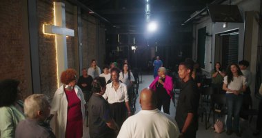 Dua ve ibadete katılan cemaat, ruhani bağlantılara odaklanmış, modern evanjelik kilise ortamında lider rehberlik hizmeti